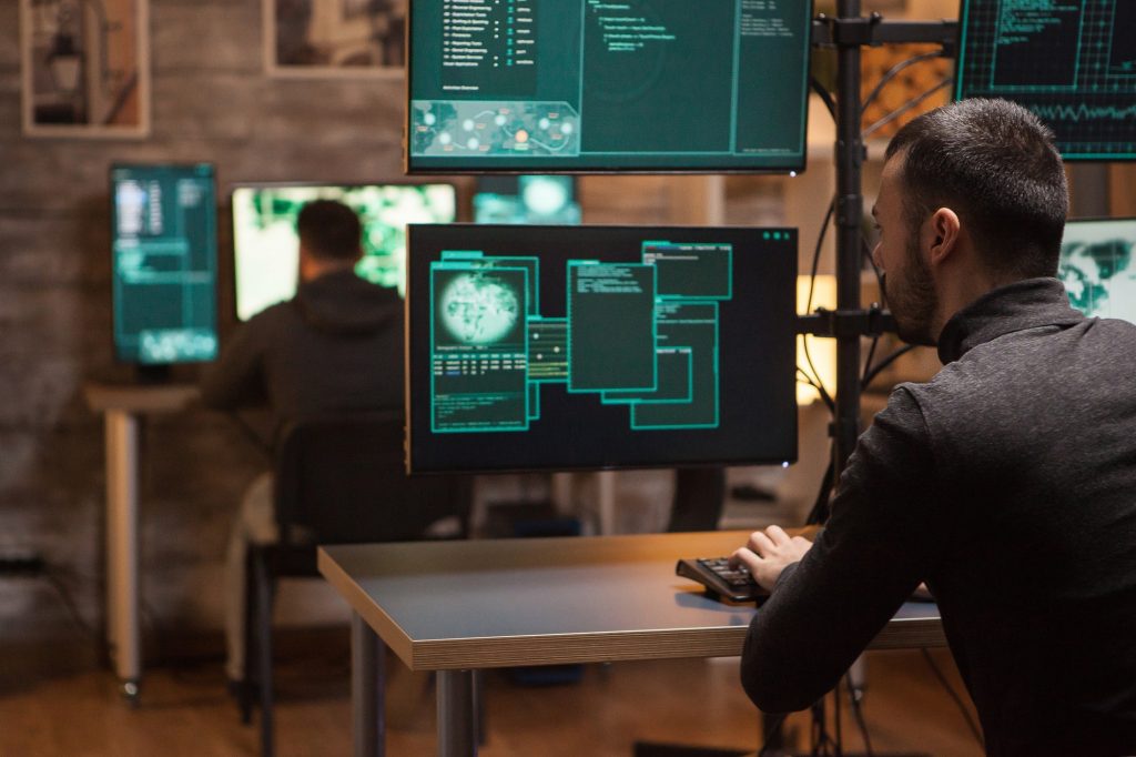 back-view-of-hackers-working-on-making-a-dangerous-malware-e1615279178691.jpg